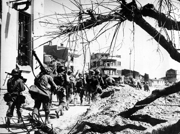 Progression des troupes au carrefour de la poste. / Coll. E. Renoux