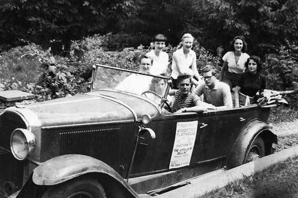 Woodstock 1950 : Larry Hagman (derrière), Georges Dupont (au volant). L'affiche annonce l'Apollon de Bellac de J. Giraudoux. / Photo : Georges Dupont